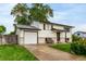 Traditional home featuring a well-manicured lawn, attached garage, and a cozy front porch at 7912 Fenton St, Arvada, CO 80003