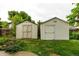Two backyard sheds offer ample storage, nestled among green foliage and a well-manicured lawn at 7912 Fenton St, Arvada, CO 80003