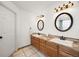 Bright bathroom with double sinks, two mirrors, updated lighting, and new faucets at 2753 E 139Th Dr, Thornton, CO 80602