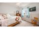 Sun-filled bedroom features neutral paint and carpet, television, and a soft bed with patterned pillows and throw at 2753 E 139Th Dr, Thornton, CO 80602