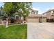 Attractive two-story home with a brick facade, three-car garage, well-maintained lawn, and beautifully landscaped garden beds at 2753 E 139Th Dr, Thornton, CO 80602