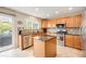 Sunlit kitchen features an island, stainless appliances, granite countertops and access to the backyard at 2753 E 139Th Dr, Thornton, CO 80602
