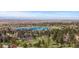 Wide aerial view of a serene neighborhood with a lake and lush green trees at 5414 Golden Currant Way, Parker, CO 80134
