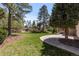 An expansive backyard features a stone patio, mature trees, and lush green lawn at 5414 Golden Currant Way, Parker, CO 80134