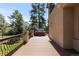 Backyard with a large deck and hot tub with lush trees and blue sky at 5414 Golden Currant Way, Parker, CO 80134