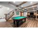 Finished basement boasts a pool table and custom bar with wood beams at 5414 Golden Currant Way, Parker, CO 80134