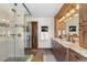 Bathroom featuring double vanity, granite countertop, wood cabinets, and a glass-enclosed shower at 5414 Golden Currant Way, Parker, CO 80134