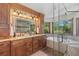 Bathroom featuring double vanity, granite countertop, wood cabinets, glass-enclosed shower, and soaking tub at 5414 Golden Currant Way, Parker, CO 80134