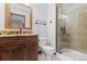 Bathroom featuring single vanity, granite countertop, wood cabinets, and a glass-enclosed shower at 5414 Golden Currant Way, Parker, CO 80134