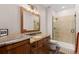 Bathroom featuring granite countertops, dual sinks, and a walk-in shower at 5414 Golden Currant Way, Parker, CO 80134