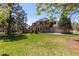 Back of house with a stone and stucco exterior features lush green lawn and mature trees at 5414 Golden Currant Way, Parker, CO 80134