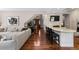 Open-concept living room features hardwood floors, a cozy sofa, and access to the kitchen and staircase at 5414 Golden Currant Way, Parker, CO 80134