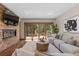 Cozy living room featuring stone fireplace, access to a deck, hardwood floors and comfortable seating at 5414 Golden Currant Way, Parker, CO 80134