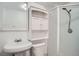 Neat bathroom with a stand up shower and white cabinet above the toilet at 7618 Umatilla St, Denver, CO 80221