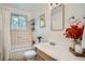 Bright bathroom with a shower-tub combo, a vanity sink, and tiled walls at 7618 Umatilla St, Denver, CO 80221