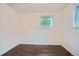 Clean bedroom featuring hardwood floors and large windows letting in natural light at 7618 Umatilla St, Denver, CO 80221