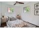 Bedroom featuring two windows, a ceiling fan, and a patterned bedspread at 7618 Umatilla St, Denver, CO 80221