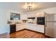 Well-maintained kitchen featuring white cabinets, modern appliances, and ample counter space with tile backsplash at 7618 Umatilla St, Denver, CO 80221