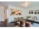 Inviting living room with seating, hardwood floors, and an open view to the modern kitchen with barstool seating at 7618 Umatilla St, Denver, CO 80221