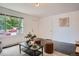 Bright living room with hardwood floors, ample seating, and a large window overlooking the front yard at 7618 Umatilla St, Denver, CO 80221