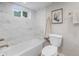 Modern bathroom features marble-look tiled walls, a white tub, and fixtures at 2260 S Lewiston St, Aurora, CO 80013