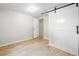 Cozy bedroom boasts light wood-look floors and a white sliding barn door at 2260 S Lewiston St, Aurora, CO 80013