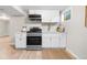 Well-lit kitchen features stainless steel appliances, white cabinets, and wood-style floors at 2260 S Lewiston St, Aurora, CO 80013