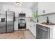 Well-lit kitchen featuring stainless steel appliances, sleek white cabinets, and modern finishes at 2260 S Lewiston St, Aurora, CO 80013