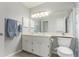 Well-lit bathroom with a double sink vanity, a large mirror, and a shower with a patterned curtain at 11147 W 17Th Ave # 103, Lakewood, CO 80215