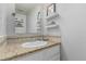 Clean bathroom featuring granite counters, stylish backsplash, and decorative shelves and artwork at 11147 W 17Th Ave # 103, Lakewood, CO 80215