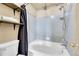 Well-lit bathroom with a bathtub and a shower with blue tiling and storage shelves at 11355 Haswell Dr, Parker, CO 80134