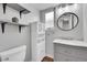 Well-lit bathroom with neutral grey walls, open shelves, storage cabinet, and marble countertop vanity at 11355 Haswell Dr, Parker, CO 80134
