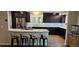 Modern kitchen with granite countertops, stainless steel appliances, dark cabinets, and four bar stools at 11355 Haswell Dr, Parker, CO 80134