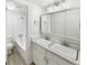 Bathroom features double sinks, tiled shower over tub, and good lighting at 2401 S Gaylord St # 206, Denver, CO 80210