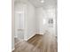 Light and airy hallway with light hardwood floors and white walls at 1975 S Coolidge Way, Aurora, CO 80018