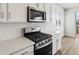 Modern kitchen features stainless steel appliances, white cabinetry, and a sleek backsplash at 1975 S Coolidge Way, Aurora, CO 80018