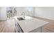 Bright kitchen island features a stainless steel sink, faucet, and light countertops, with hardwood flooring and outdoor access at 1975 S Coolidge Way, Aurora, CO 80018