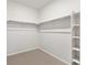 Spacious walk-in closet featuring shelving, closet rods, and neutral carpeting at 1975 S Coolidge Way, Aurora, CO 80018