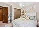 Bright bedroom with floral bedding, closet with wooden door, and access to storage at 3838 S Waco St, Aurora, CO 80013