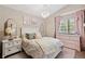 Charming bedroom featuring floral bedding, crystal chandelier, and large window at 3838 S Waco St, Aurora, CO 80013