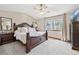 Comfortable main bedroom with carpet, large window, ceiling fan and a stately dark wooden bed at 3838 S Waco St, Aurora, CO 80013