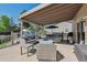 Covered wooden patio furnished with comfortable seating and a grill at 3838 S Waco St, Aurora, CO 80013