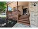 Inviting covered porch featuring classic wood railing, brick accents, and a welcoming entry at 3838 S Waco St, Aurora, CO 80013