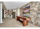 Basement rec room featuring a stone wall, entertainment center, shuffleboard table and a built-in kitchenette at 7343 Upton Ct, Castle Rock, CO 80104