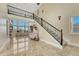 Bright and airy living room with high ceilings, large windows, and elegant staircase with ironwork at 7343 Upton Ct, Castle Rock, CO 80104