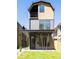 Modern two-story home featuring a black metal roof, a covered porch, and a balcony on the second floor at 263 S Jackson St, Denver, CO 80209