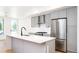 Modern kitchen with stainless steel appliances, gray cabinetry, and a large island at 263 S Jackson St, Denver, CO 80209