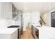 Bright kitchen with modern appliances, gray cabinets and white countertops and light wood floors at 263 S Jackson St, Denver, CO 80209