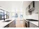 Open concept kitchen with stainless steel appliances, gray cabinets, and a quartz countertop island at 263 S Jackson St, Denver, CO 80209