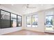 Bright living room featuring large windows and a modern ceiling fan, with wood floors and a glass door at 263 S Jackson St, Denver, CO 80209